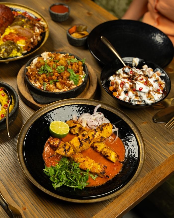 A delicious spread of Indian cuisine featuring chicken tikka, biryani, and more, perfect for an authentic dining experience.