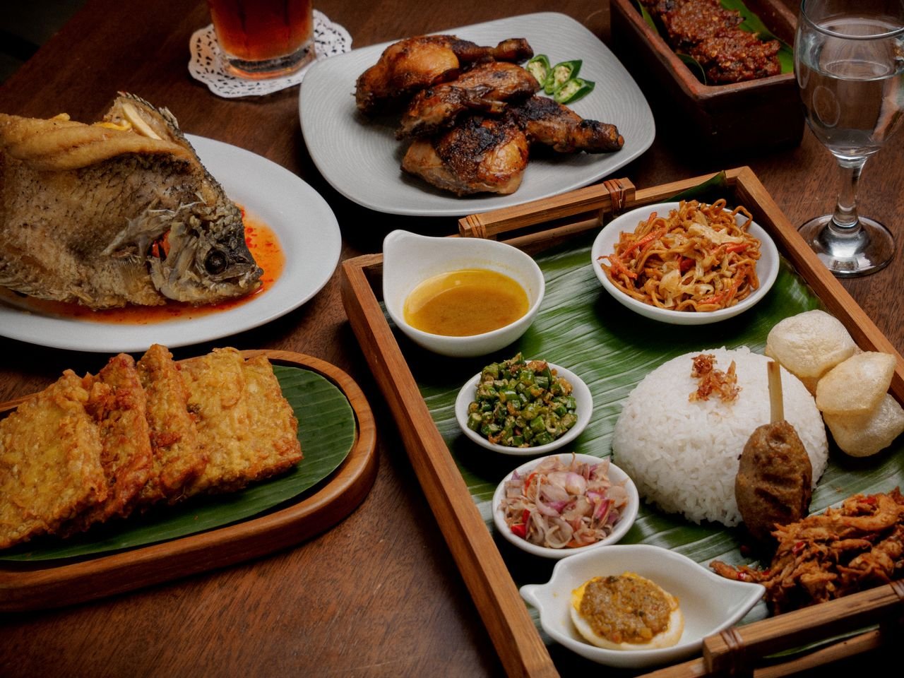 Discover a delicious array of traditional Indonesian dishes beautifully presented on a wooden table.